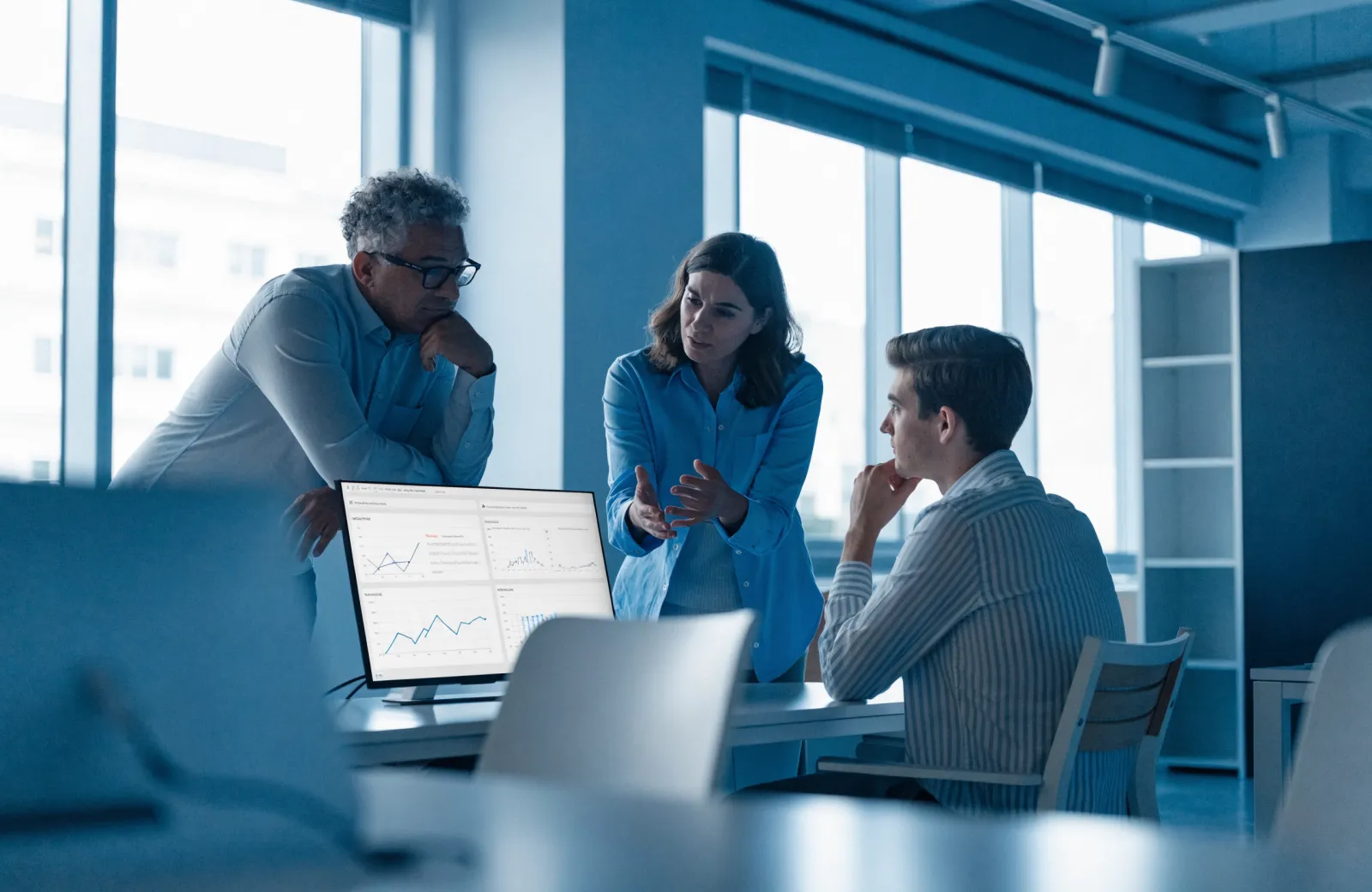 Technology advisors collaborating with a client over analytics dashboards